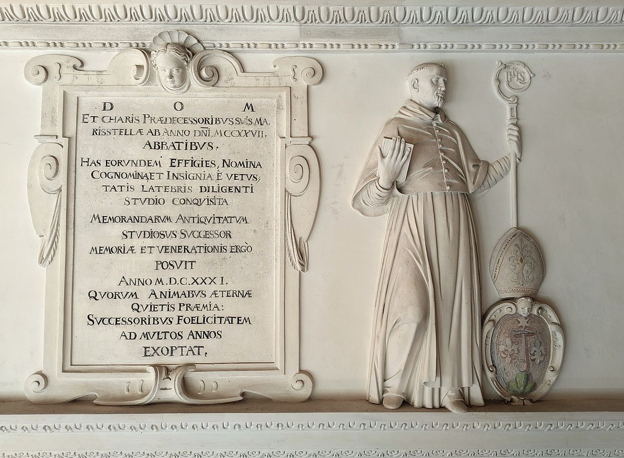 Relieffigur: Abt mit Buch und Wappen