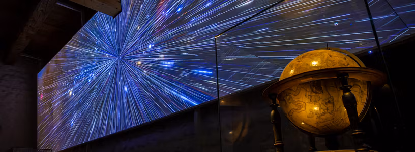 Ausstellung "Observatorium" auf der Klosterhalbinsel Wettingen: Grosse Leinwand mit Sternenhimmel, davor ein grosser historischer Globus.