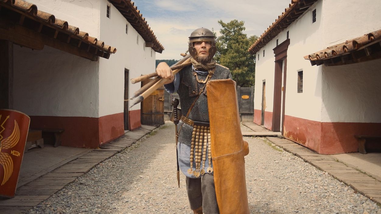 Ein als römischer Legionär gerüsteter Mann steht in der Mannschaftsunterkunft im Legionärspfad Vindonissa.