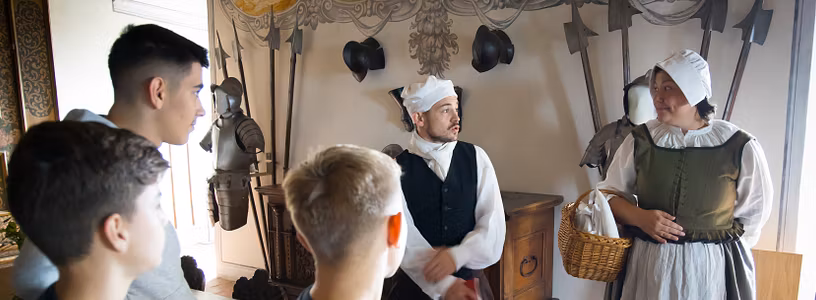 Ein Knecht und eine Magd mit Schulklasse im Wohnmuseum von Schloss Wildegg