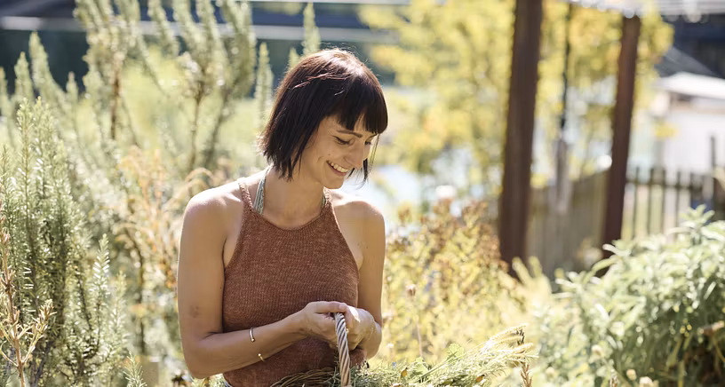 Eine Frau mit Kräuterkorb in einem Garten