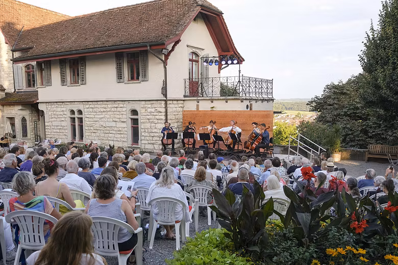 Hof von Schloss Wildegg mit Konzertbühne und vielen Besucherinnen und Besuchern.. Im Hintergrund die Villa von Schloss Wildegg.
