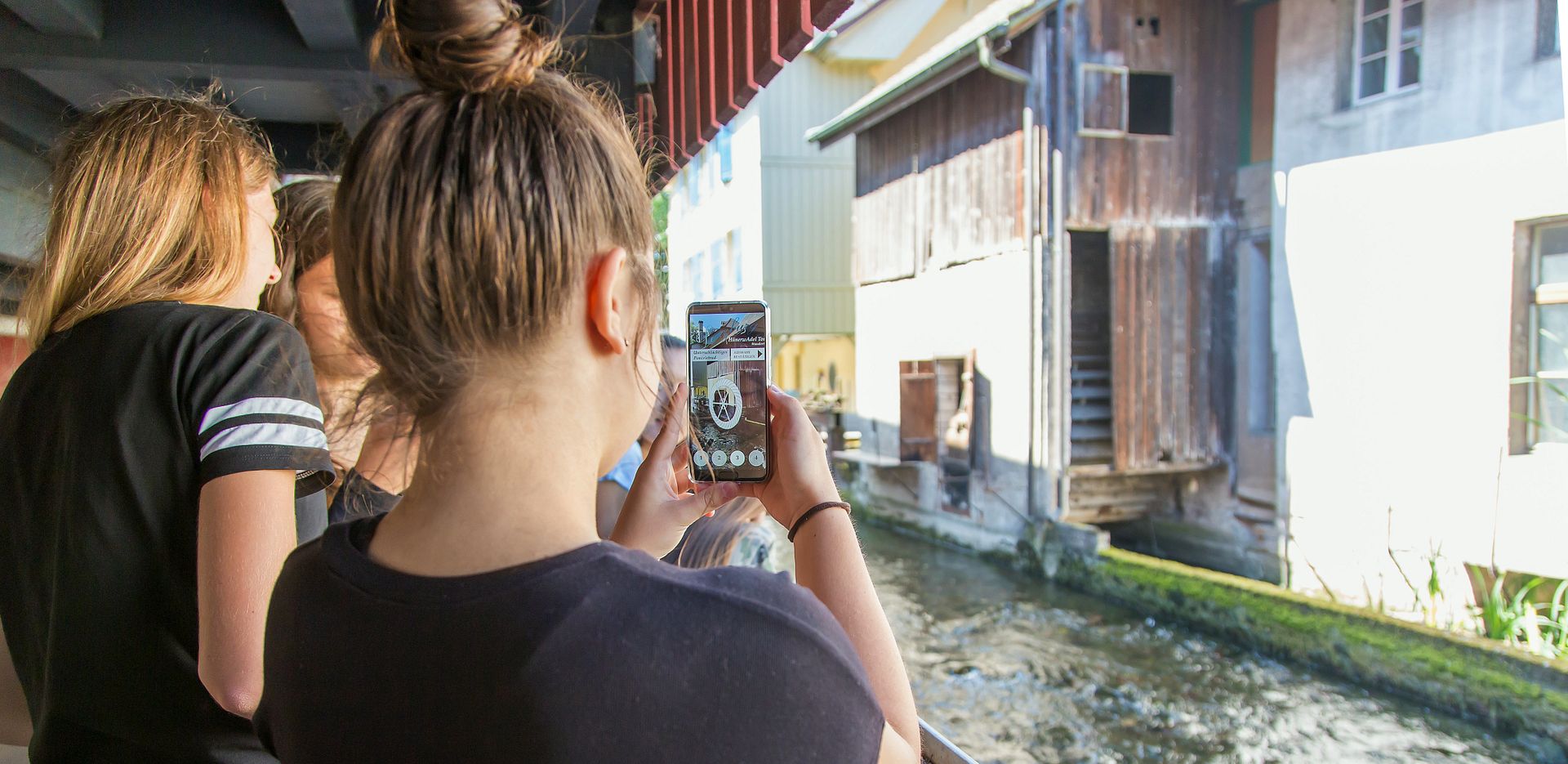 Zwei Schülerinnen auf dem Industriekultour Aabach mit einem Handy