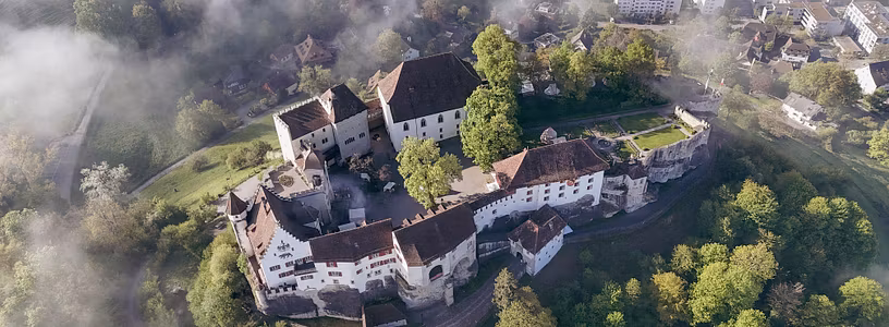 Luftaufnahme von Schloss Lenzburg: Schloss auf einem Hügel im Sommer