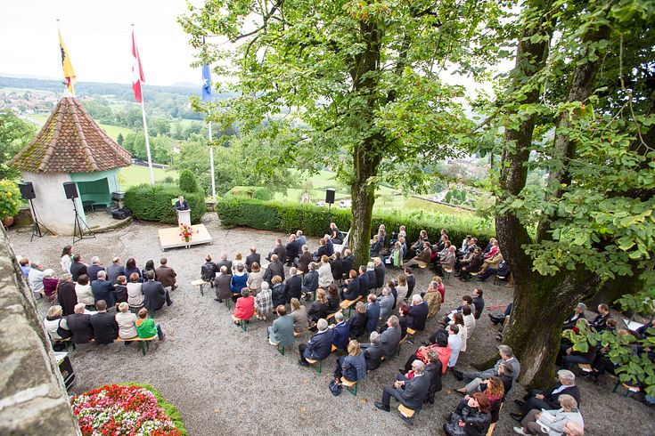Lindenterrasse Schloss Wildegg: Eine Veranstaltung mit vielen Menschen, die in Reihen sitzen. Vorne ein Redner.