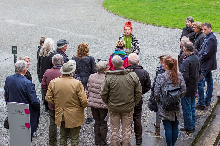 Gruppenführung im Schlosshof Schloss Hallwyl: Die Gruppe ist der Führerin zugeneigt