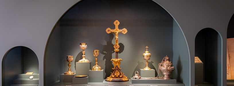 Ausstellung in der Mönchskirche Kloster Wettingen: Verschiedene Objekte in einer Vitrine, u.a. ein grosses Altarkreuz