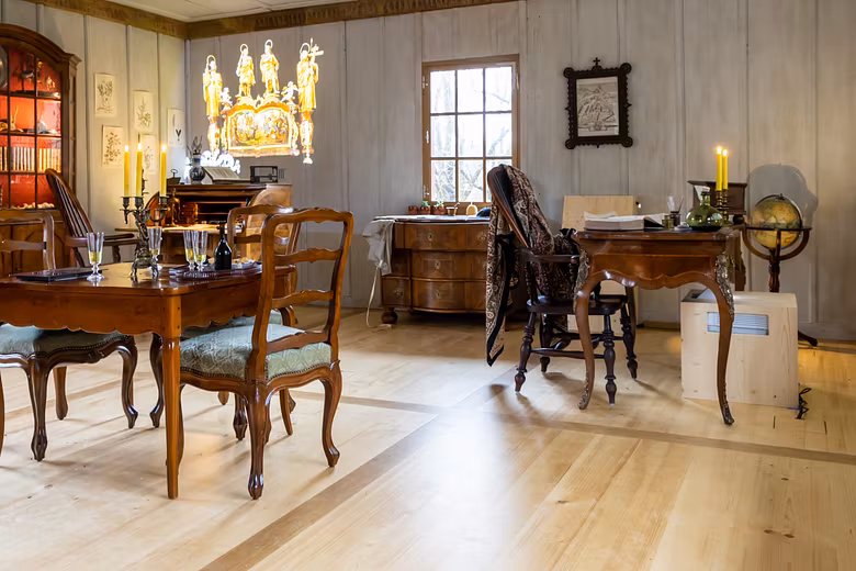 Innenraum vom Abthaus auf der Klosterhalbinsel Wettingen mit historischen Möbeln und einer Projektion an den Wänden.