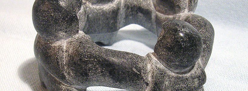 Mehrere Specksteinfiguren, die im Kreis miteinander verbunden sind.