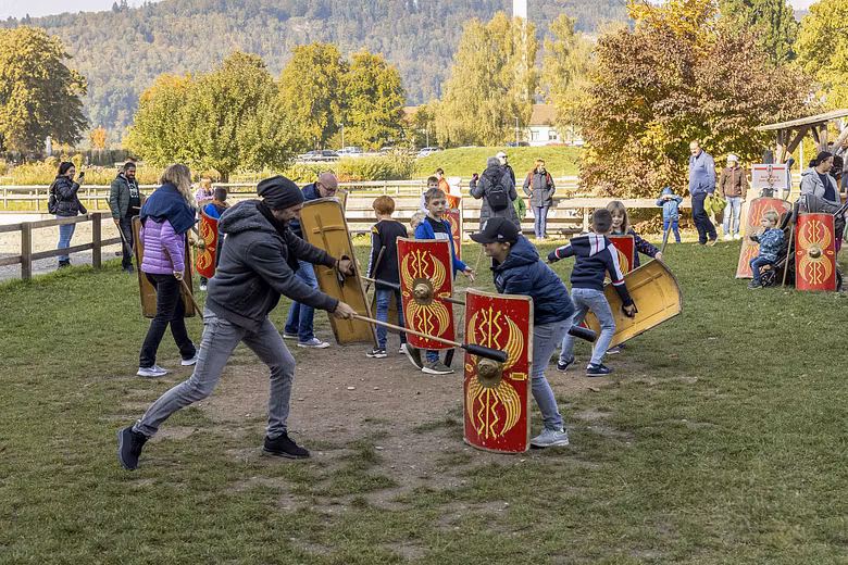 Eine Gruppe Eltern und Kinder kämpfen im Legionärspfad Vindonissa gegeneinander.