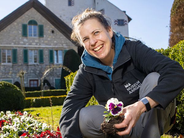 Gärtnerin Melissa Gögele im Rosengarten von Schloss Wildegg (im Hintergrund das Rebhaus und Schloss Wildegg)