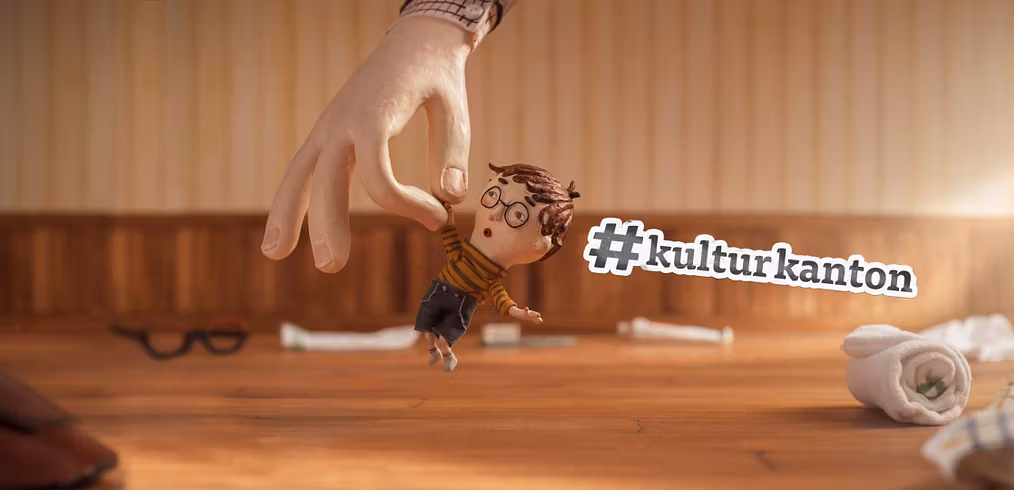Ausscnitt aus einem Animationsfilm: Ein kleiner Bub wird von einer Hand in die Luft gehoben.