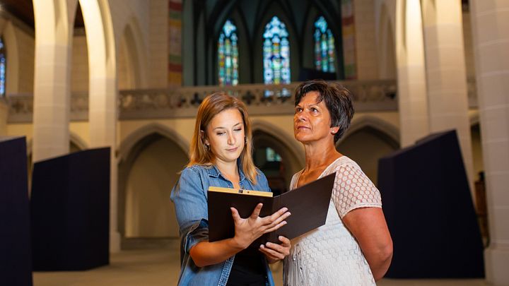 Zwei Besucherinnen schauen auf die Decke mit demTablet in der Hand im Kloster Königsfelden