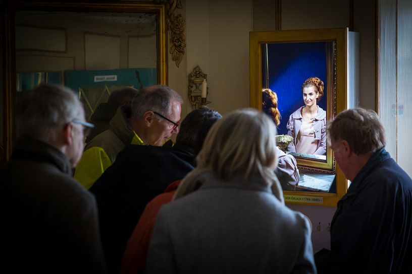Besucherinnen und Besucher hören dem sprechenden Portraits gespannt zu (hier spricht die Zofe)