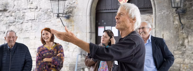 Ein Museumführer mit einer Besuchergruppe vor dem Tor von Schloss Habsburg.