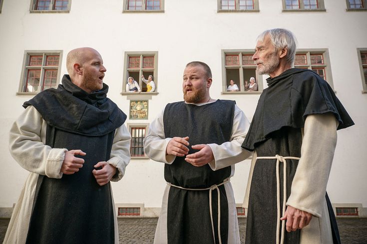 Theater "Kloster, Macht, Lebenslust" auf der Klosterhalbinsel Wettingen: Drei Mönche vor dem Kloster Wettingen, dahinter blicken Klostermägde aus den Fenstern.