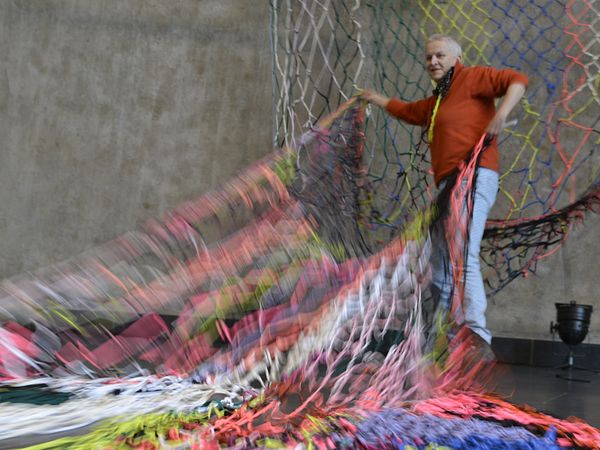 Künsterlin Vera Staub hantiert mit einer grossen Netzvorrichtung