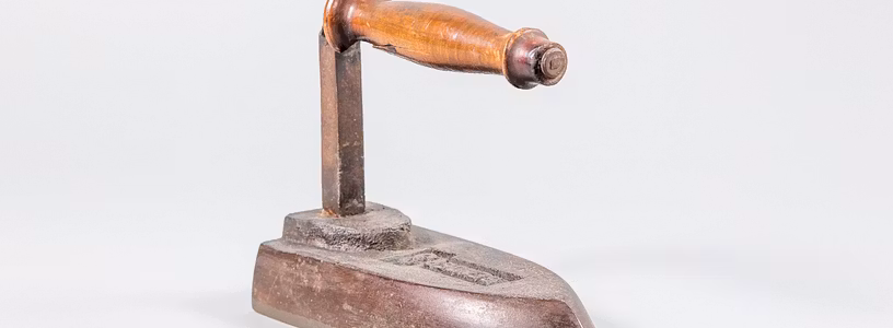 Historisches altes Bügeleisen aus der Sammlung Museum Aargau auf weissem Grund.