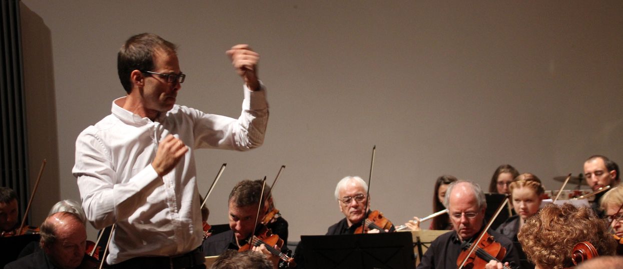Dirigent steht vor Orchester