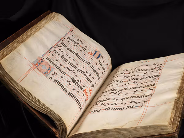 Aufgeschlagener Band 2 des Wettinger Graduale, auf dessen Seiten Gesänge mit kunstvollen Initialen zu erkennen sind.