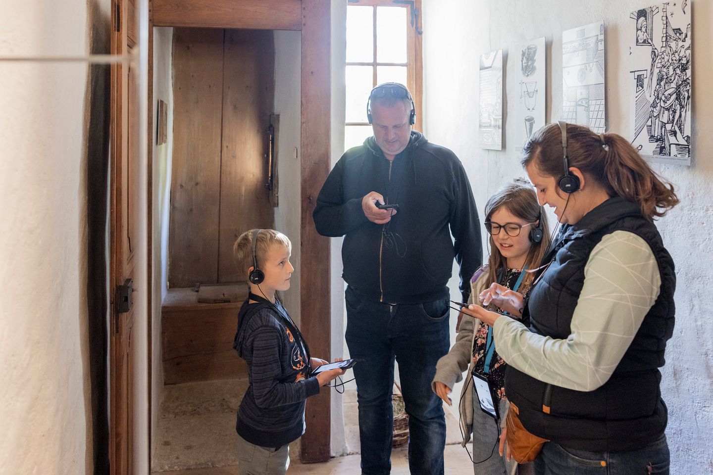 Eine Familie mit Kopfhörern im Museum von Schloss Hallwyl