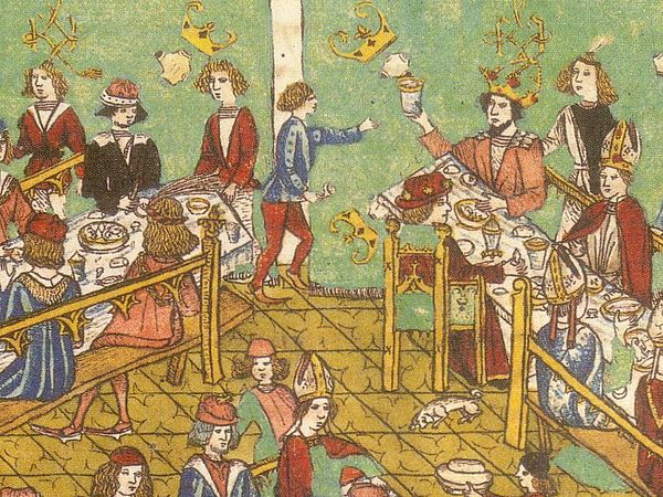Der Kaiser sitzt mit einigen Kurfürsten am Tisch rechts oben und erhebt sein Glas. Ein Page eilt herbei. Gegenüber in Schwarz sitzt Karl der Kühne. An den Wänden sind kostbare Wandbehänge zu sehen.