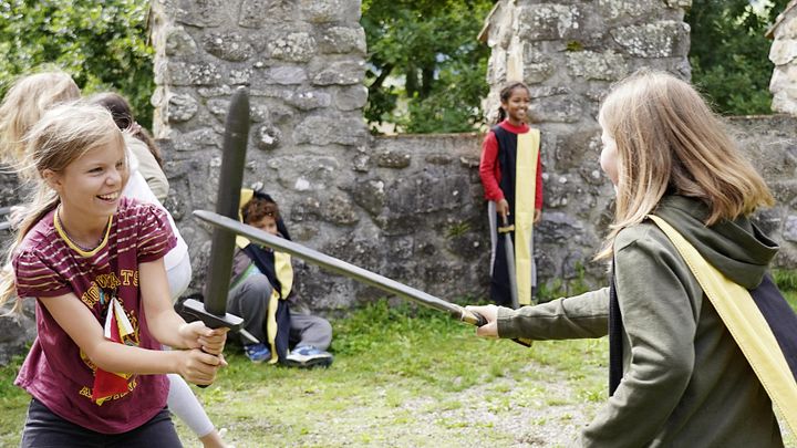 Zwei Mädchen beim Duell mit Schwertern auf Schloss Hallwyl (Workshop für Schulen),