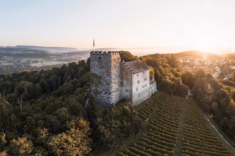 Luftaufnahme von Schloss Lenzburg im mystischen Gegenlicht
