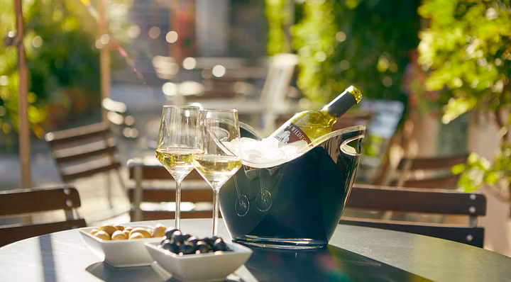 Wein und Weingläser auf einem Tisch auf der Terrasse im Bistro Schloss Wildegg