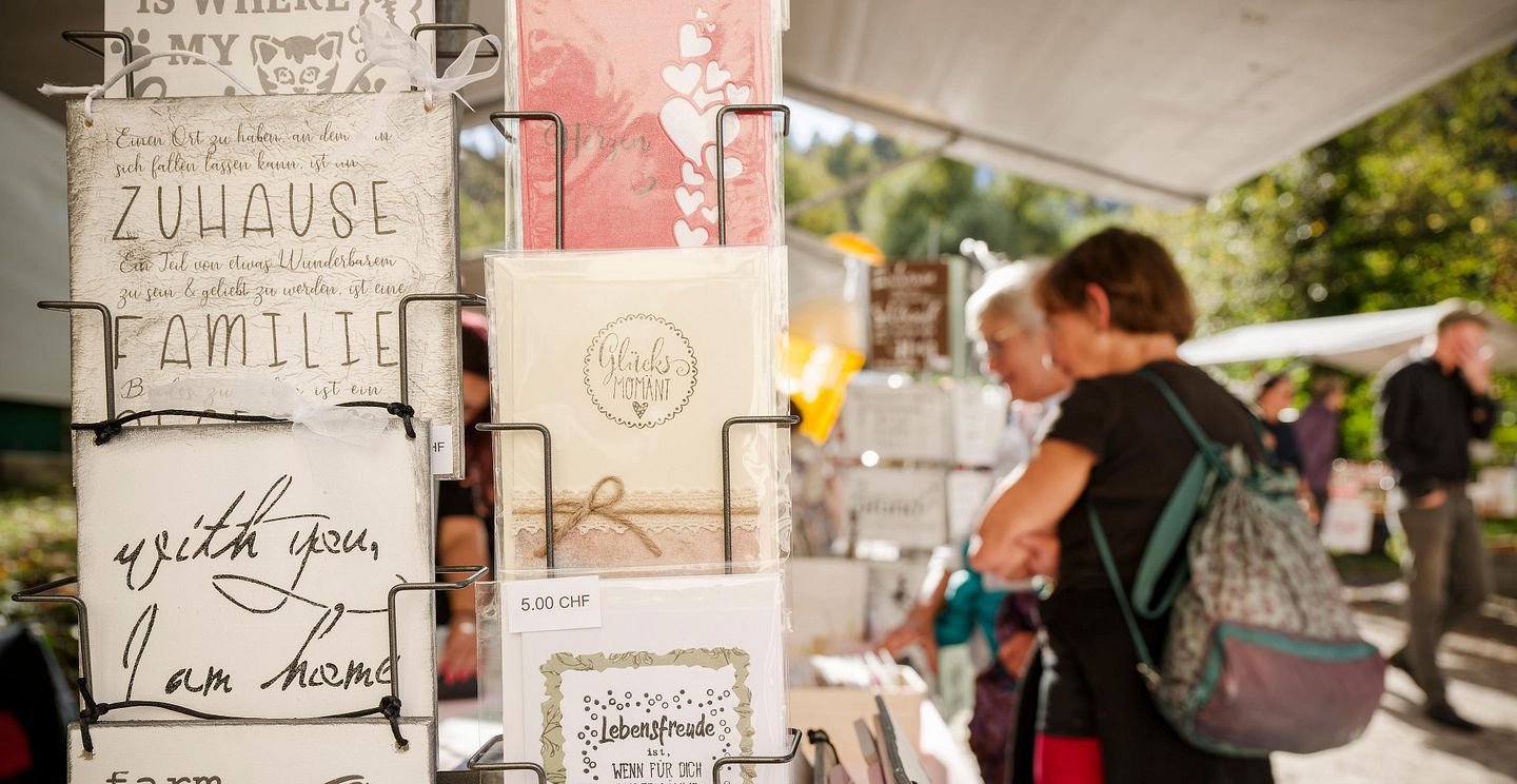Postkarten eines Standes am Herbstmarkt Klosterhalbinsel Wettingen, im Hintergrund mehrere Personen