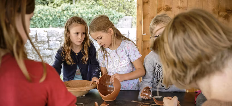 Kinder setzen im römischen Garten vom Vindonissa Museum Scherben eines Kruges zusammen.