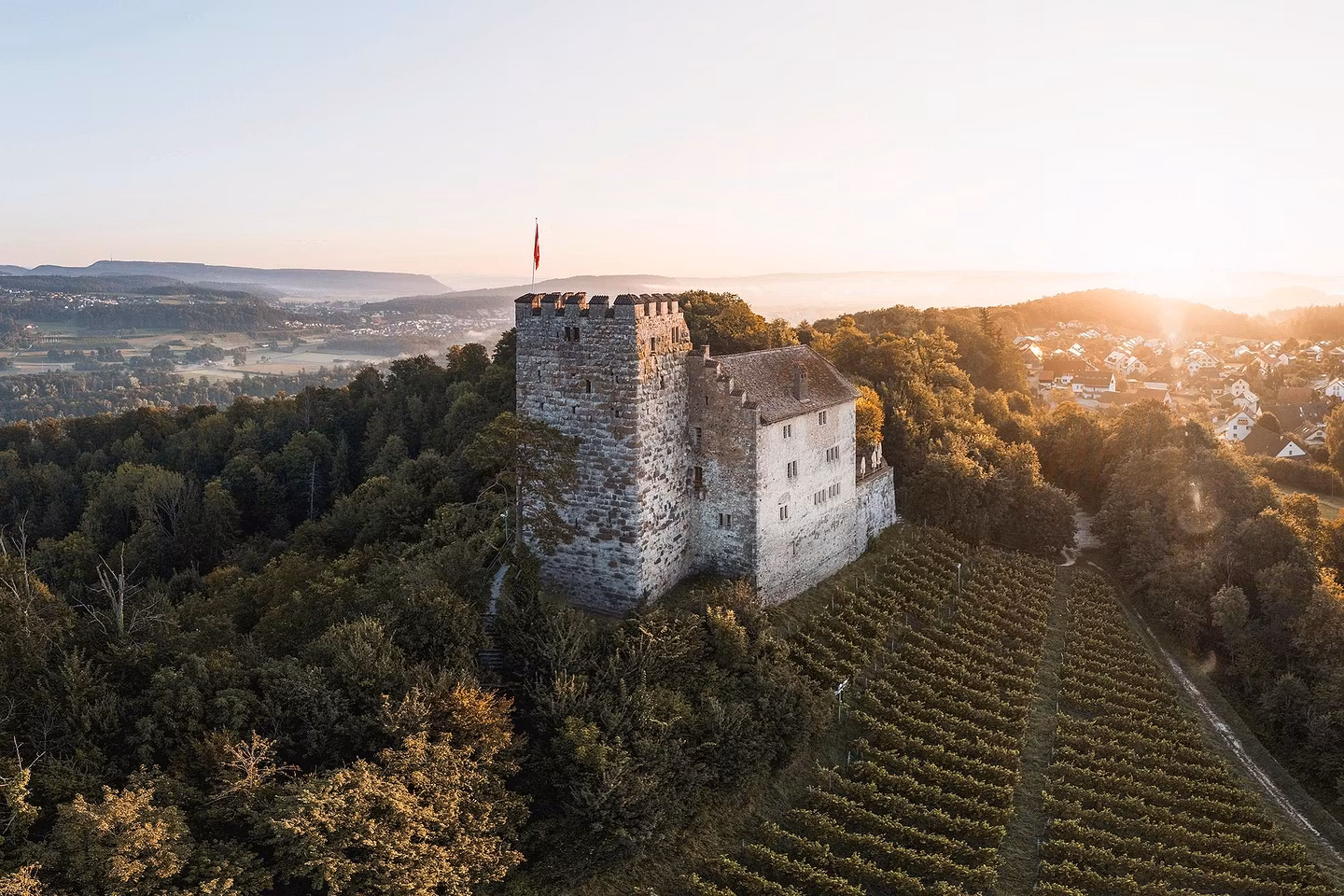 Luftaufnahme von Schloss Lenzburg im mystischen Gegenlicht