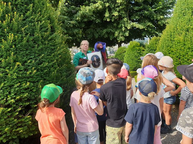 Führung "Theo Regenwurm": Kinder hören mit dem Rücken gewandt dem Führer gespannt zu.