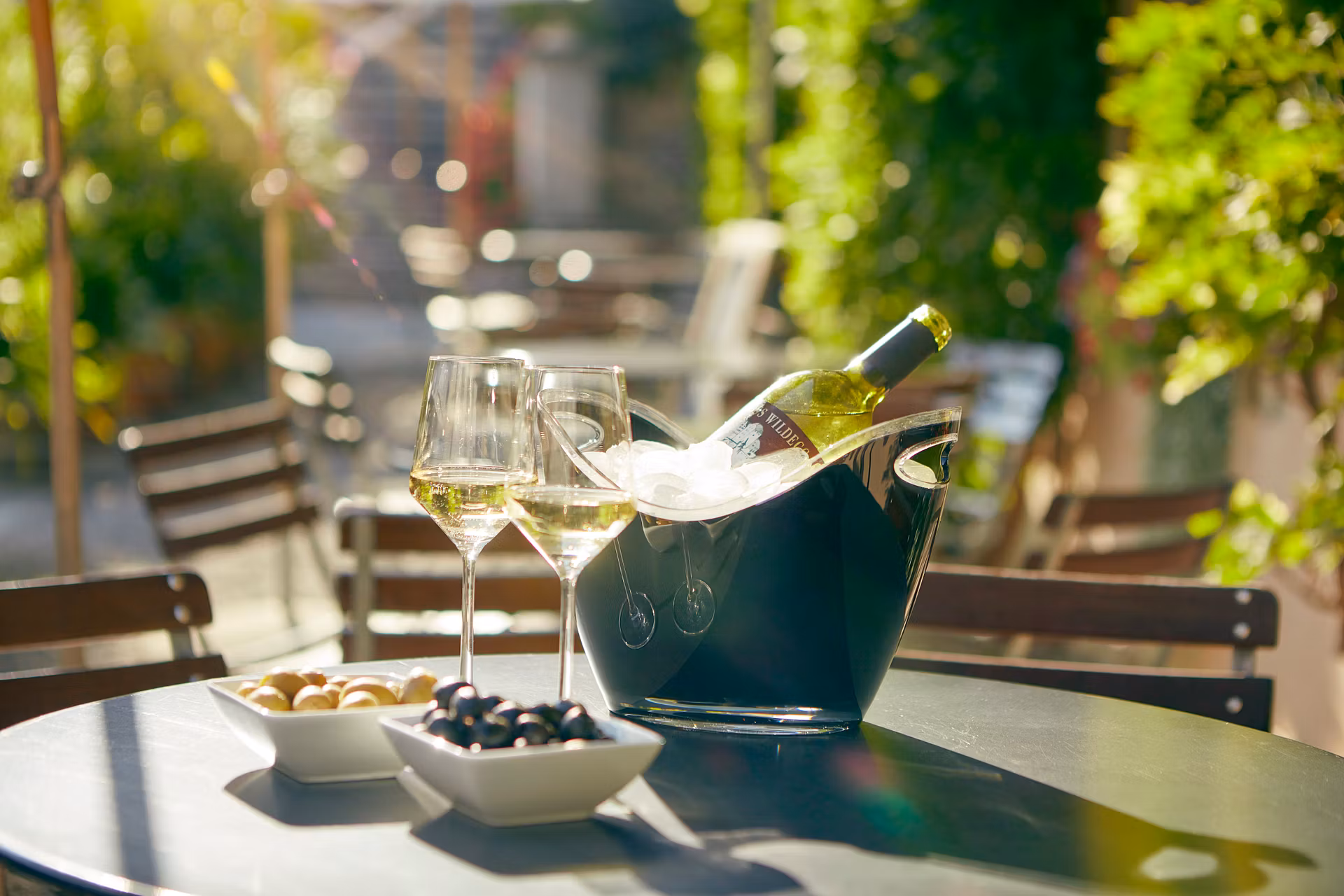 Wein und Weingläser auf einem Tisch auf der Terrasse im Bistro Schloss Wildegg