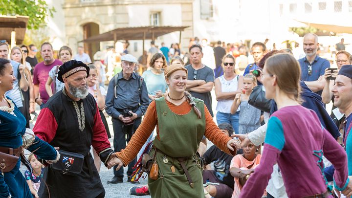 Eine Gruppe Personen tanzt am Mittelaltermarkt auf Schloss Lenzburg in historischer Kleidung zu Musik