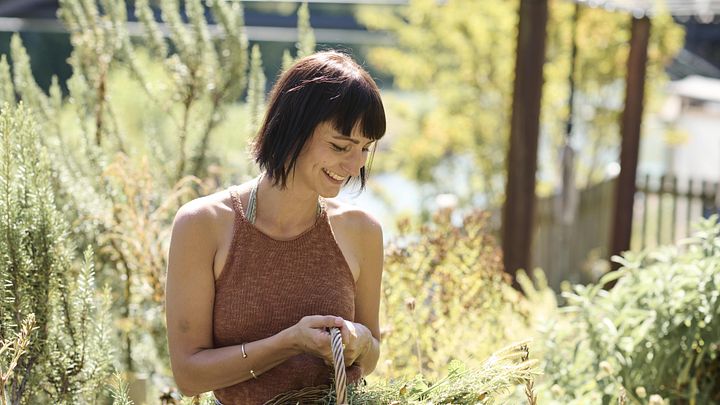 Eine Frau mit Kräuterkorb in einem Garten