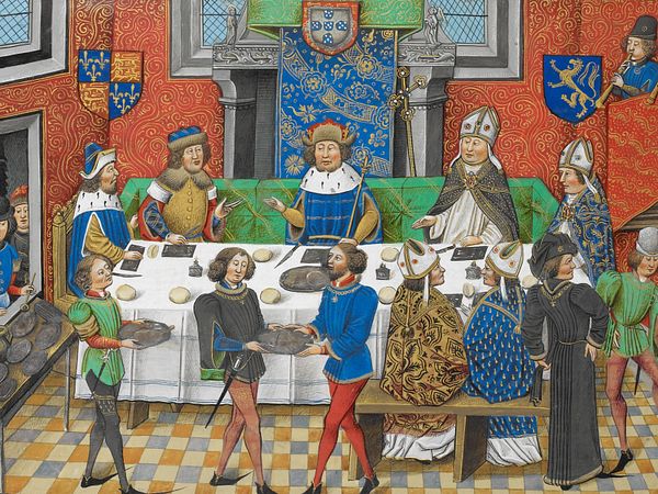 Der Herzog von Lancaster speist mit dem König von Portugal, Johann I. Auf der mit einem Tuch bedeckten Tafel befinden sich flache, rechteckige Teller, Messer, Brote und Salzfässchen. Höflinge bringen die Speisen, die von einer Durchreiche vom Koch auf Platten geschöpft werden. Auf einem Balkon rechts oben spielen Musiker. 