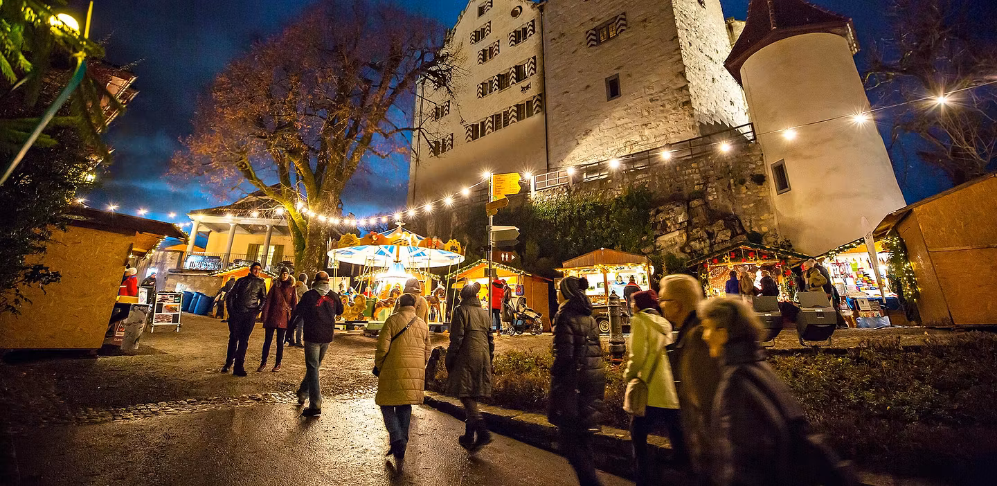 Wiehnachtsmärt mit beleuchteten Marktständen vor Schloss Wildegg